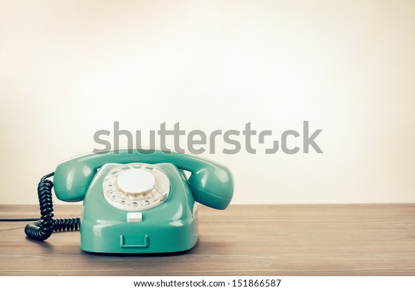 Retro rotary telephone on\
wood table