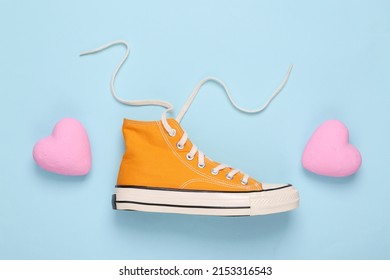 Retro sneaker with hearts on blue background. Romantic, love concept. Top view. Minimal flat lay still life