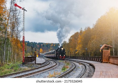 Retro Steam Train Departs From The Station Wooden Platform At Cloudy Autumn Evening.