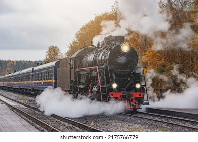 Retro Steam Train Departs From The Station Wooden Platform At Cloudy Autumn Evening.