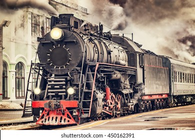 Retro steam train departs from the station. - Powered by Shutterstock