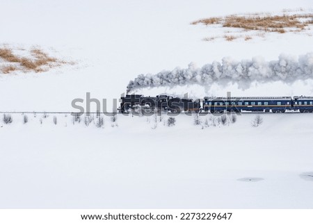 Retro steam train moves at winter day time.