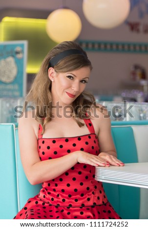 Retro style of 1950. Young woman in a restaurant.