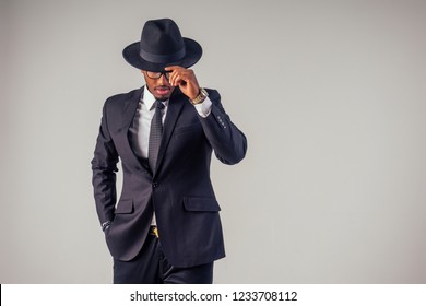 Retro Style African American Business Man Mafia Model In Dark Suit And Black Hat In Studio On White Background