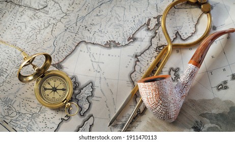 Retro Style Golden Compass (sundial), Elegant Smoking Pipe And Old White Nautical Chart Close-up. Vintage Still Life. Gentleman, Sailing Accessories. Travel And Navigation Theme