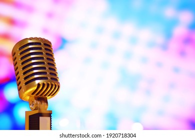 Retro style microphone on background with backlight. Vintage silver Microphone for sound, music, karaoke. Speech broadcast equipment. Live pop, rock musical performance. Selective focus