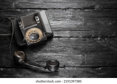 Retro Style Rotary Phone On The Black Wooden Desk Table Background With Copy Space.