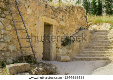 A retro style stone house in the open air museum of Nazareth Village Israel. Houses in the modern Nazareth can be seen in the background. This site gives a look at life in the time of Jesus Christ 