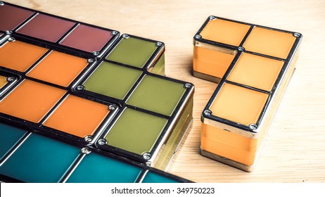 Retro styled or retro color geometric shapes of four square blocks on wooden surface. Concept of classic puzzle game. Isolated on white background. Slightly de-focused and close-up shot. Copy space.