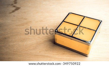 Retro styled or retro color geometric shapes of four square blocks on wooden surface. Concept of classic puzzle game. Isolated on white background. Slightly de-focused and close-up shot. Copy space.
