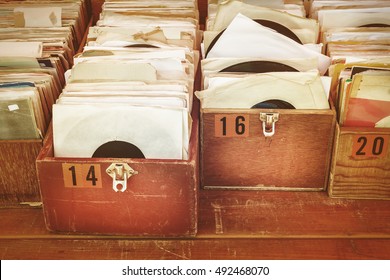Retro styled image of boxes with vinyl turntable records on a flee market