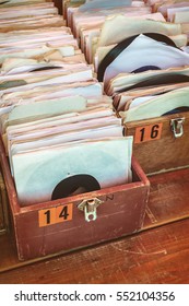 Retro styled image of boxes with vinyl turntable records on a flee market