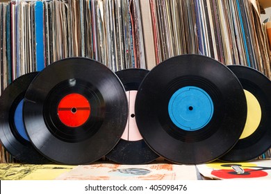 Retro styled image of a collection of old vinyl record lp's with sleeves on a wooden background.  Copy space.