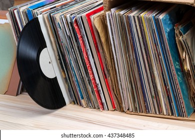 Retro Styled Image Of A Collection Of Old Vinyl Record Lp's With Sleeves On A Wooden Background. Copy Space.