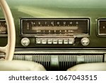 Retro styled image of an old car radio inside a green classic car