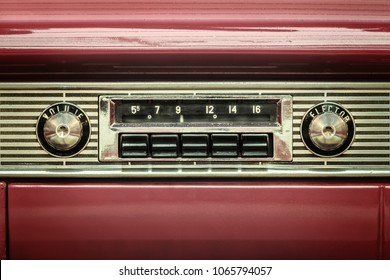 Retro styled image of an old car radio inside a red classic car