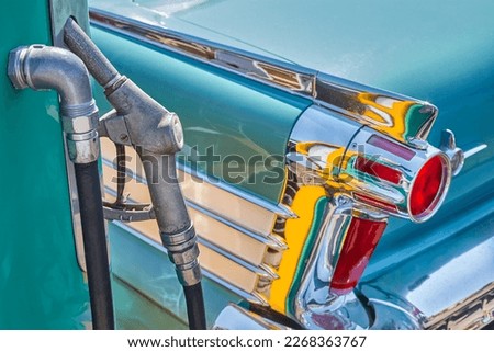 Retro styled image of an old fuel pump and green classic car