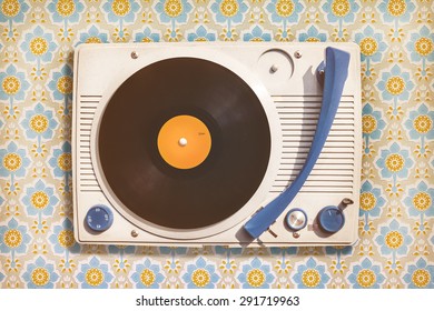 Retro styled image of an old record player on top of flower wallpaper - Shutterstock ID 291719963