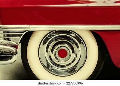 Retro styled image of the wheel of a red vintage American car
