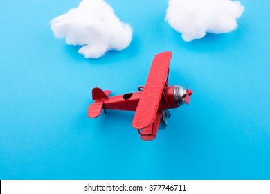 Retro styled little red model airplane in sky