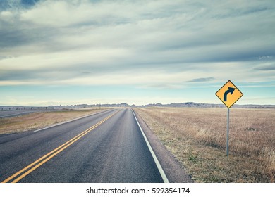 Retro stylized picture of a road with turn sign, USA. - Shutterstock ID 599354174