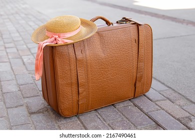 Retro suitcase and straw hat. Natural. Concept of long-distance trip, travel or emigration
