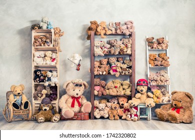 Retro Teddy Bear Plüsch Spielzeuge großartige Sammlung auf hölzernen Regalen, antiker Schaukelstuhl, alter Hocker, Schachteln vor dem Betonkletterwände. Das Konzept der Nostalgie im Kindesalter. Vintage gefiltertes Foto