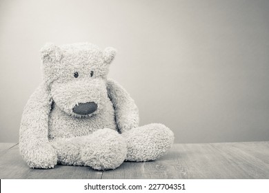 Retro Teddy Bear toy sitting alone. Vintage old style sepia photo