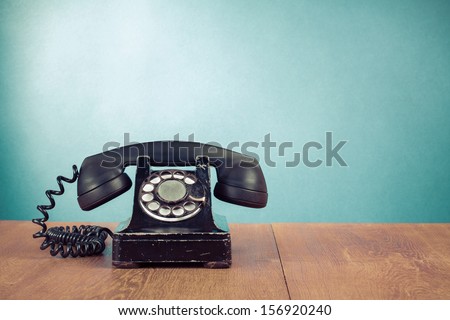 Retro telephone on table in front mint green background
