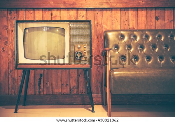 Retro television and vintage sofa with vintage wooden
background. Classic vintage style home decoration. Retro style
concept. 