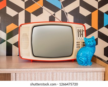 Retro Television With Vintage Wallpaper In The Background. Interior Decoration Ceramic Figure From The 70s