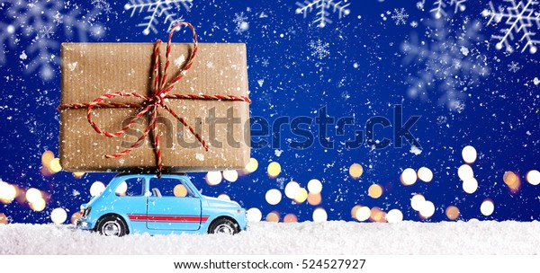 Retro toy car delivering Christmas or New Year\
gifts on festive blue\
background