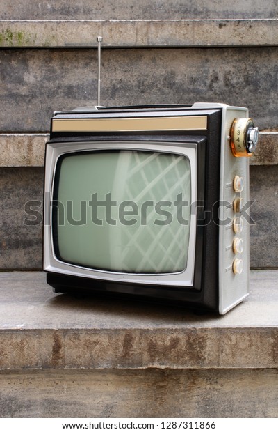 Retro TV\
as obsolete dusty TV receiver laid on\
stairs