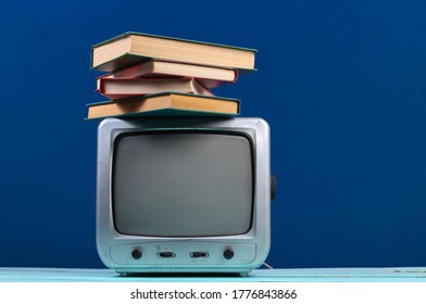 Retro Tv Receiver With Stack Of Books On Classic Blue Background