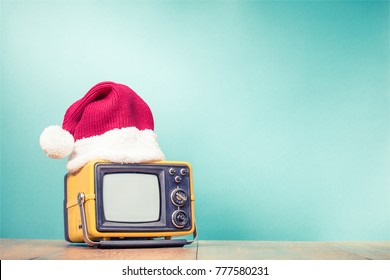 Retro TV in Santa hat front mint green background. Holidays congratulation in mass media concept. Vintage old style filtered photo - Powered by Shutterstock