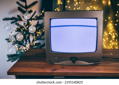 Retro TV set with glitch effect in a room with Christmas decorations on wooden table - Powered by Shutterstock