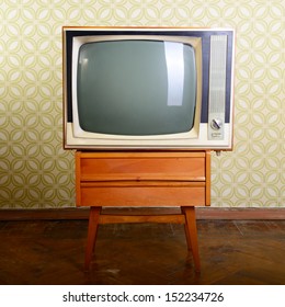 retro tv with wooden case in room with vintage wallper and parquet