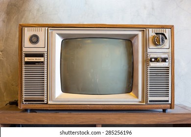 retro tv with wooden case in room with vintage wallpaper on wood table