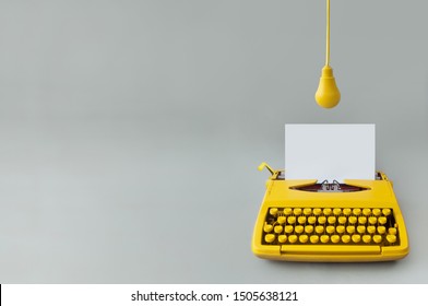 Retro typewriter with yellow hanging light bulb, inspiration, new ideas