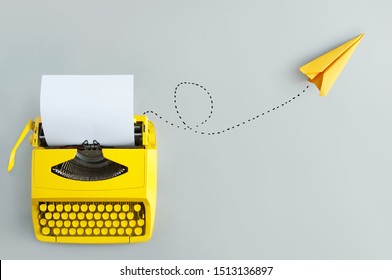 Retro typewriter with yellow paper airplane, inspiration and innovation