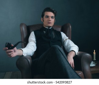 Retro victorian man sitting in leather chair holding pipe.