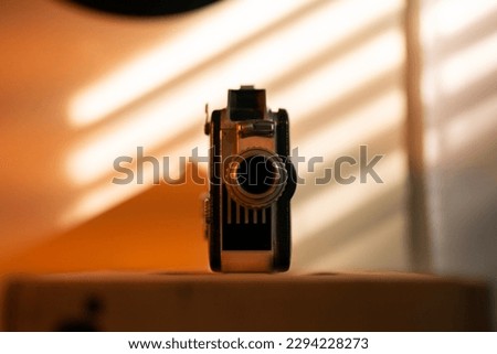 Retro vintage film camera with window shade sunset light hitting the subject. Represents filmmaking, movies, cinematography.