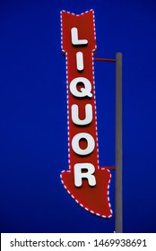 Retro Or Vintage Grunge Liquor Store Arrow Sign With Dark Blue Sky Background.
