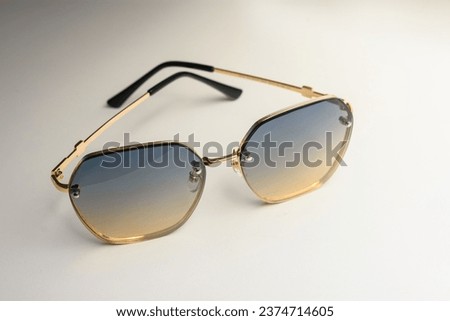 Retro or vintage style lenses or sunglasses from the 1980s, on a butter-colored background. Graphic resource.