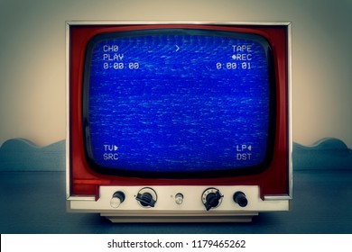 A Retro Vintage TV Showing An Old Bad Broken VHS Tape Playing. Blue Screen With Various Info And Noise.
