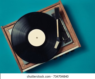 Retro vinyl player on a blue background. Entertainment 70s. Listen to music. Top view. - Shutterstock ID 734704840