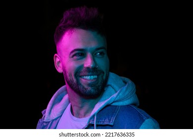 The Retro Wave Or Synth Wave Portrait Of A Young Happy Man At Studio. High Fashion Male Model In Colorful Bright Neon Lights Posing On Black Background. Art Design Concept