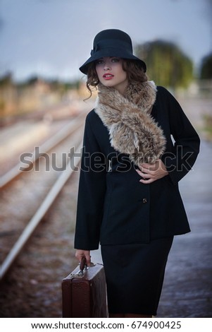 retro woman with case at railway station
