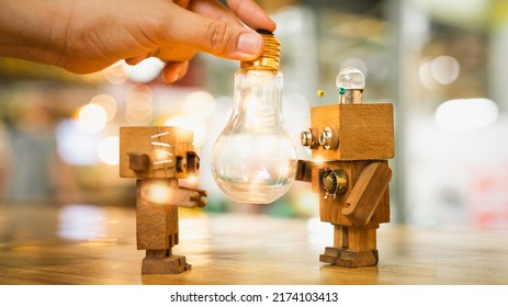 Retro wood robot with  hand holding light bulb with bokeh light background,, nature power energy concept.