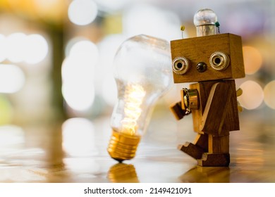 Retro wood robot hold light bulb with two hand with bokeh light background,, nature power energy concept.